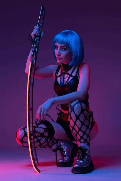 Mulher nua cyberpunk sentado com espada brilhante — Fotografia de Stock