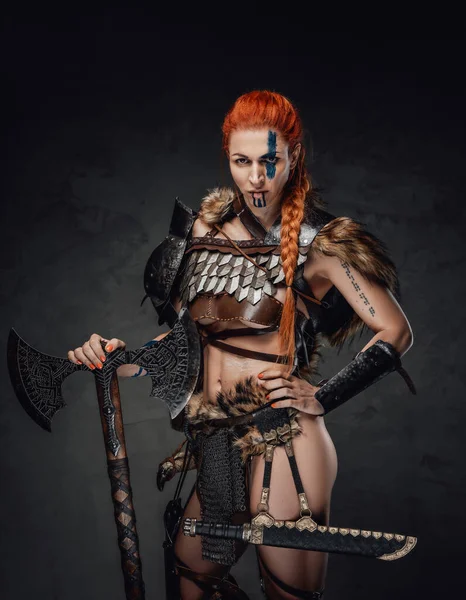 Furious woman warrior with muscular build and axe in dark background