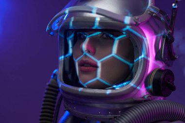 Miğferli uzay kadınının aydınlatılmış stüdyo fotoğrafı.