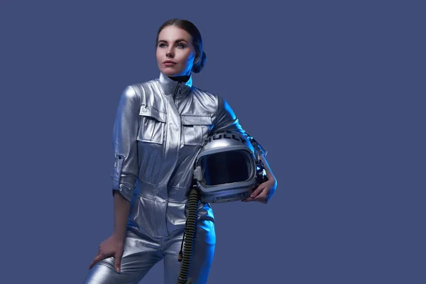 Modern female cosmonaut posing against blue background — Stock Photo, Image