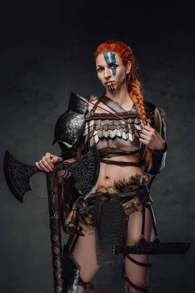 Serious nordic female warrior with axe and armour in dark background — Stock Photo, Image