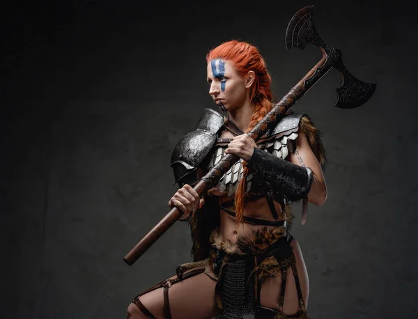 Armoured nordic woman fighter with axe on her shoulder in studio — Stock Photo, Image