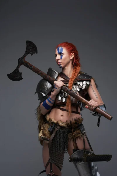 斧とグレーの背景に装甲服を持つ美しい武道の女性 — ストック写真