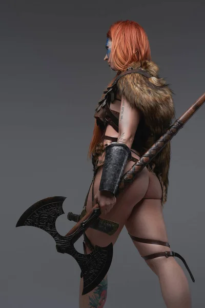 Ruiva mulher sexy guerreiro do norte com machado em fundo cinza — Fotografia de Stock