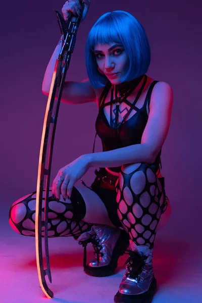 Nudo cyberpunk donna seduta con la spada incandescente — Foto Stock