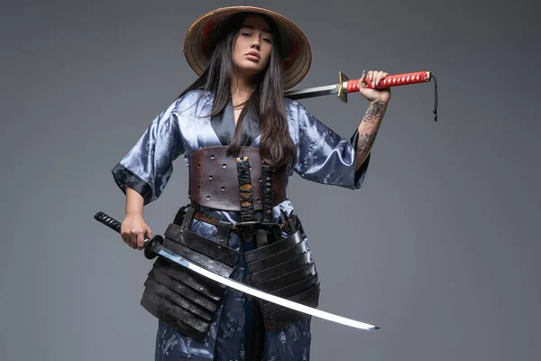 Femme guerrière orientale avec chapeau et katana — Photo