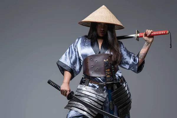 Young female warrior with samurai swords and bamboo hat — Stock Photo, Image