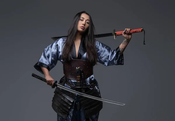 Mujer peligrosa samurai posando con espadas de samurai — Foto de Stock
