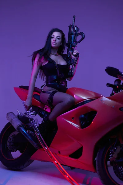 Urban biker donna con fucile e spada in posa su moto — Foto Stock