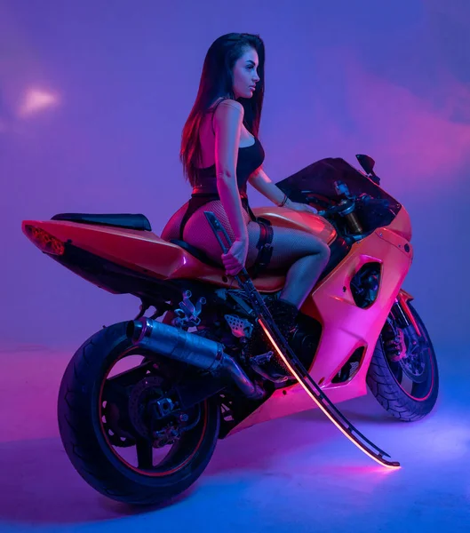 Elegante donna in posa sulla moto e impugnare la spada — Foto Stock