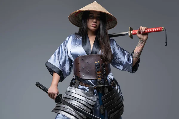 Young female warrior with samurai swords and bamboo hat — Stock Photo, Image