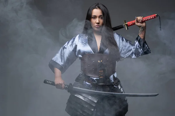 Oriental woman samurai with katanas in fog — Stock Photo, Image
