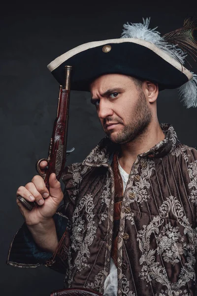 Elegância pirata com pistolas posando contra fundo escuro — Fotografia de Stock