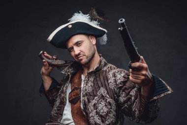 Karanlık arka planda tabancaları olan kendine güvenen bir korsan.