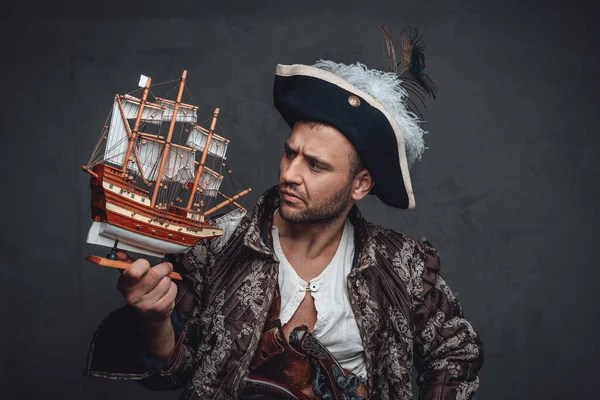 Pirata pensierosa guardando piccola nave giocattolo — Foto Stock