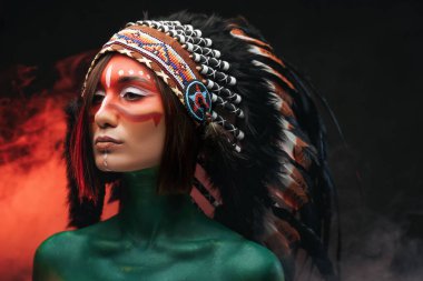 Tüy şapkalı kadın dumanlı arka plana karşı