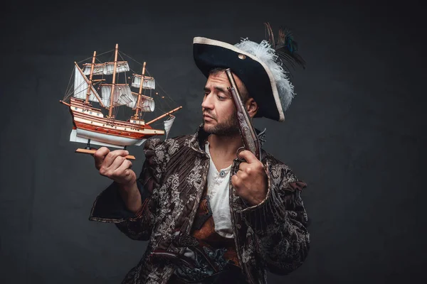 Pirata pensativo olhando para pequeno navio de brinquedo — Fotografia de Stock