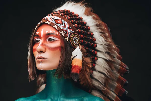 Studio shot of woman wearing indian feather headwear — Stock Photo, Image