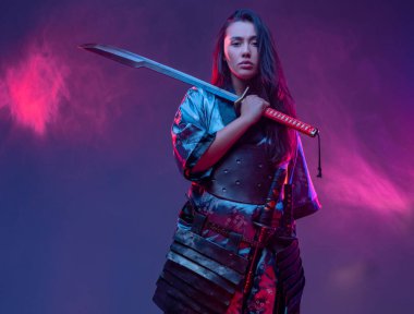 Katana 'lı samuray kıyafeti giymiş bir kadın.