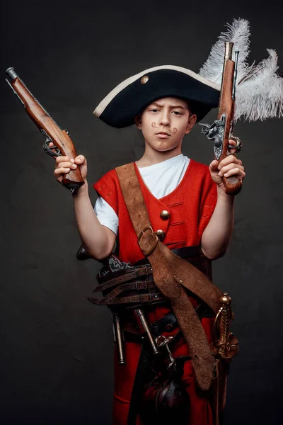 Küçük çocuk korsan şapkası ve silahlı kostüm giyiyor. — Stok fotoğraf