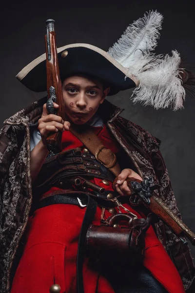 Engraçado garoto pirata fazendo cara contra fundo escuro — Fotografia de Stock