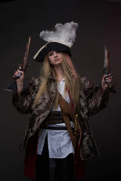 Mulher atraente pirata com armas contra fundo escuro — Fotografia de Stock