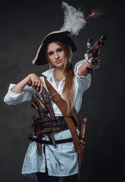 Woman pirate aiming gun against dark background — Stock Photo, Image