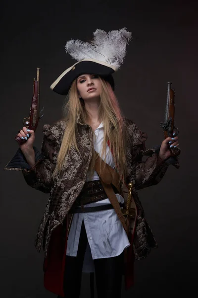 Mulher atraente pirata com armas contra fundo escuro — Fotografia de Stock