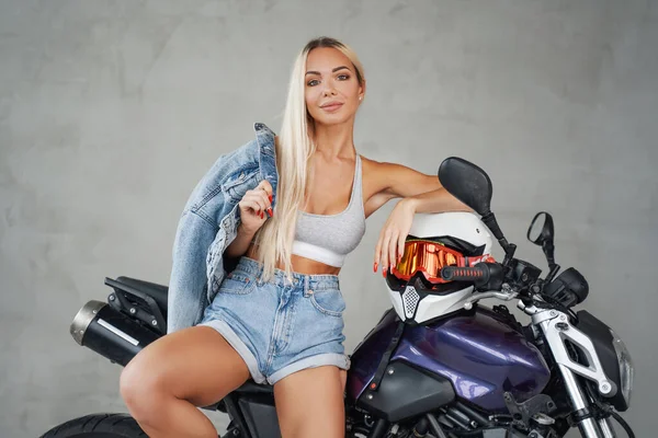 Glada kvinnliga motorcyklist poserar på sin egen motorcykel — Stockfoto