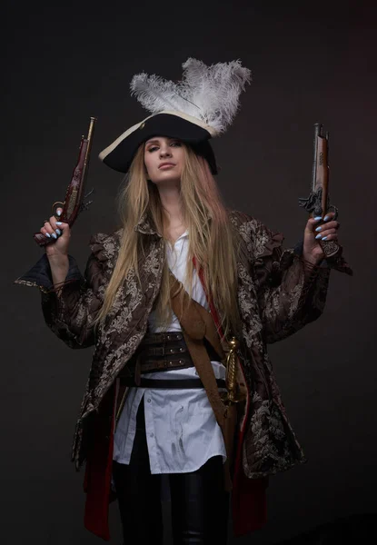 Atractiva mujer pirata con armas contra el fondo oscuro —  Fotos de Stock