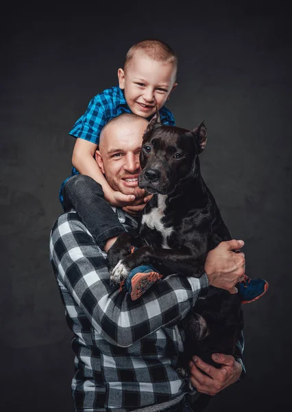 Vuxen far kramar sin son och mörkbrun hund — Stockfoto