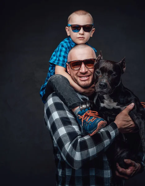 Lachende vader knuffelende hond en zijn kleine zoon — Stockfoto