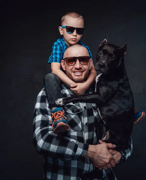 Lachende vader knuffelende hond en zijn kleine zoon — Stockfoto