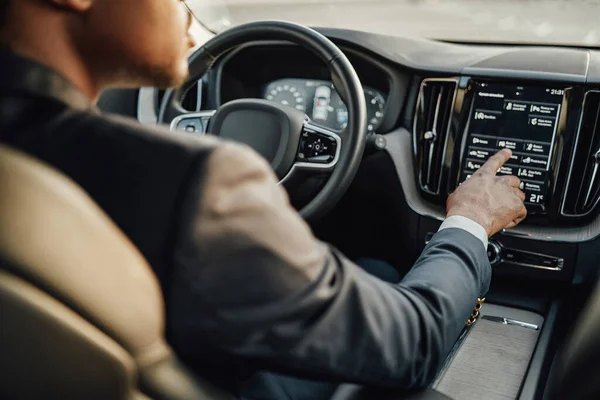 Black businessman inside car using car panel — Stock Photo, Image