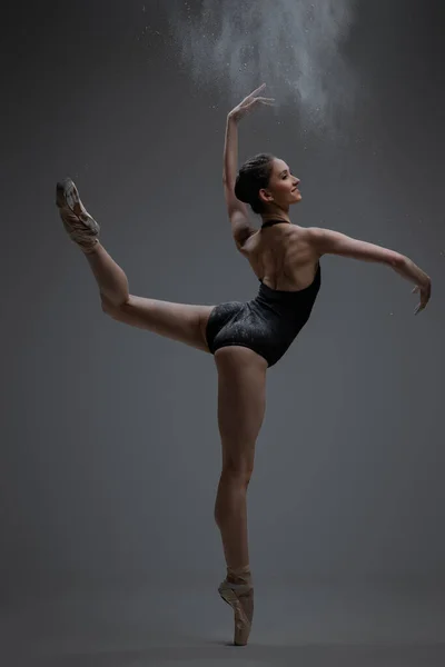 Graziosa ballerina spruzzando polvere e ballando all'interno dello studio — Foto Stock