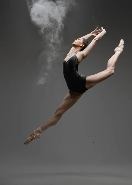 Bailarina profissional dançando em estúdio contra fundo cinza — Fotografia de Stock