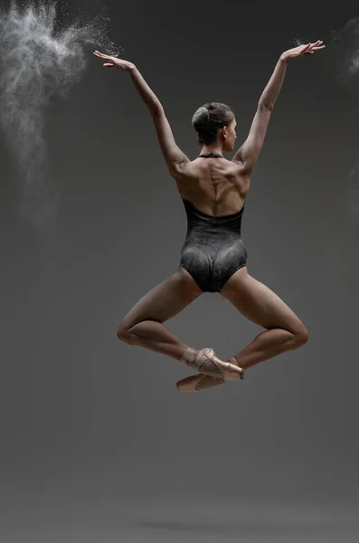Зворотний знімок стрибки балерини з витягнутими руками — стокове фото