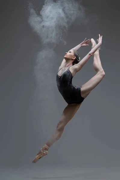Έξυπνη μπαλαρίνα που χορεύει πηδώντας πάνω σε γκρι φόντο — Φωτογραφία Αρχείου