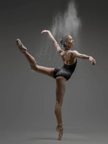 Professionele ballerina dansen in studio tegen grijze achtergrond — Stockfoto