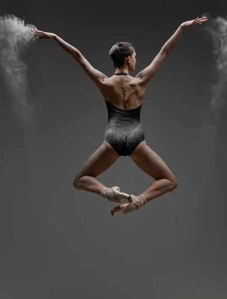 Vista posterior de la bailarina saltando con los brazos extendidos — Foto de Stock