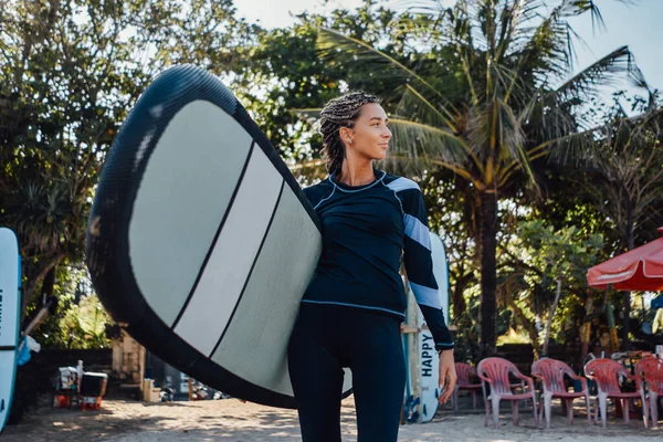 Woman in wetsuit with board and dreadlocks on beach — Stock Photo, Image