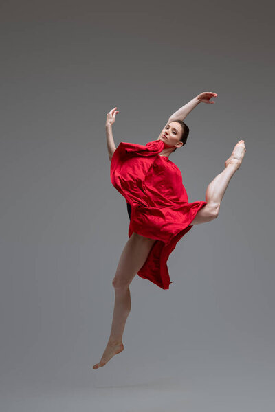 Professional ballet dancer with red silk inside studio
