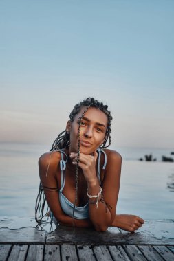 Havuzda yüzen mayo giyen mutlu kadın.