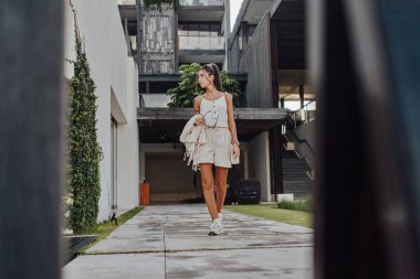 Rastalı bir kadın malikaneye karşı poz veriyor.