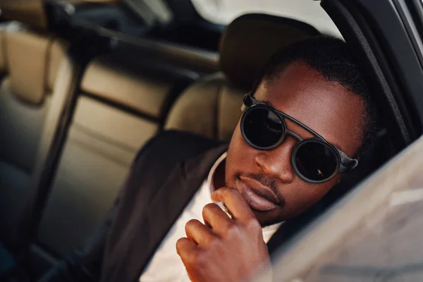 Fashionable african employee with sunglasses inside of car — Stock Photo, Image