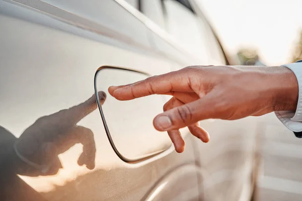 Skjuten av affärsman med fingret på bränsletank bil — Stockfoto