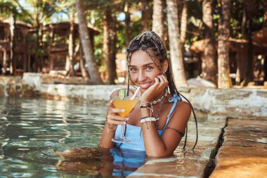 Kokteylli mutlu bir kadın otelde tatilin tadını çıkarıyor.