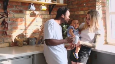 Medium shot of mixed race family of three spending time at the kitchen.