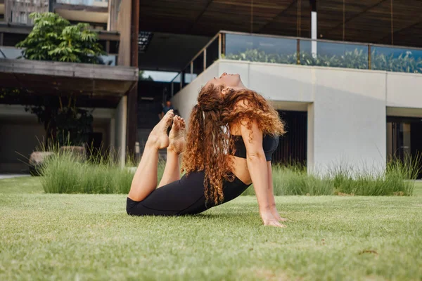 Anmutige Frau macht Yoga und streckt ihre Beine und Hände — Stockfoto