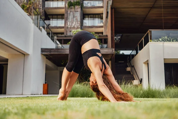 Anmutige Frau macht Yoga und streckt ihre Beine und Hände — Stockfoto